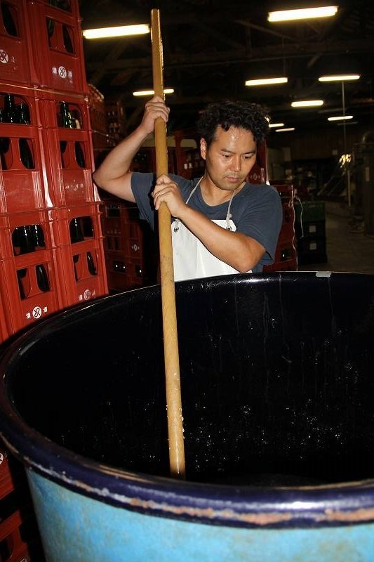 もろみを攪拌する無法松酒造の山家勉さん
